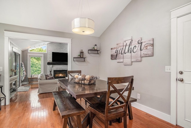 1836 Ridgewood Ave SE, Grand Rapids, MI 49506 - dining area with vaulted ceiling, a fireplace, and light wood-style floors