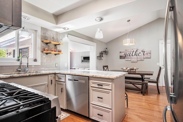 1836 Ridgewood Ave SE, Grand Rapids, MI 49506 - kitchen featuring appliances with stainless steel finishes, tasteful backsplash, light wood-style floors, a peninsula, and lofted ceiling