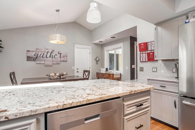 1836 Ridgewood Ave SE, Grand Rapids, MI 49506 - kitchen with stainless steel appliances, tasteful backsplash, light stone countertops, lofted ceiling, and light wood-style flooring