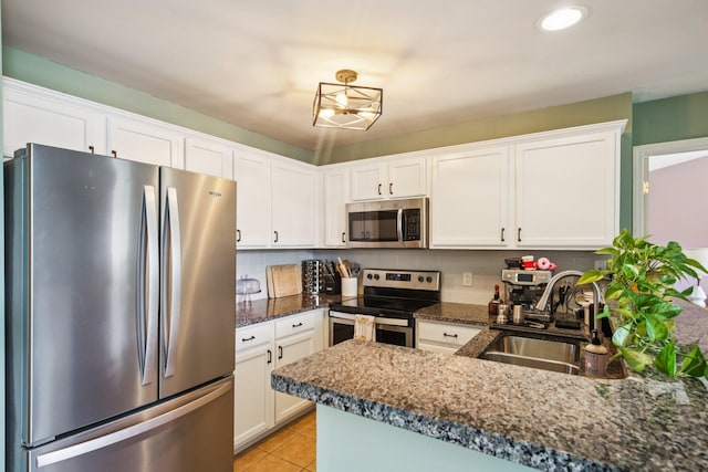 3197 Primrose Ln, Ypsilanti, MI 48197 - kitchen with stainless steel appliances, white cabinetry, light tile patterned floors, dark stone counters, and recessed lighting