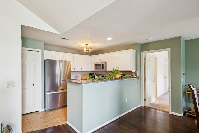 3197 Primrose Ln, Ypsilanti, MI 48197 - kitchen with stainless steel appliances, dark stone counters, white cabinets, a peninsula, and recessed lighting
