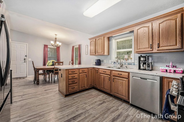 2851 18 Mile Rd, Kent City, MI 49330 - kitchen with stainless steel dishwasher, a peninsula, a chandelier, light wood-style floors, and light countertops