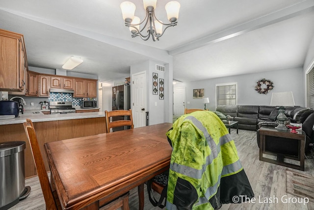 2851 18 Mile Rd, Kent City, MI 49330 - dining area featuring a chandelier, light wood finished floors, and beamed ceiling