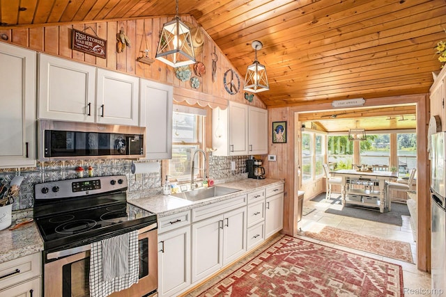 636 Swains Lake Dr, Concord, MI 49237 - kitchen featuring stainless steel appliances, lofted ceiling, wooden ceiling, wood walls, and white cabinetry