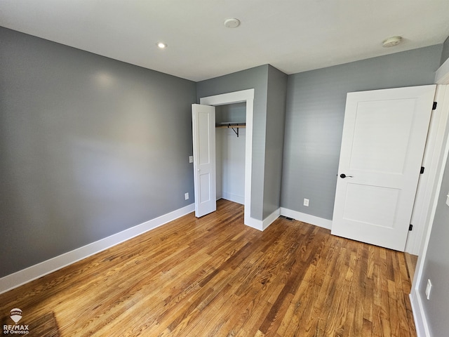 624 E Comstock St, Owosso, MI 48867 - unfurnished bedroom featuring wood finished floors, a closet, and recessed lighting