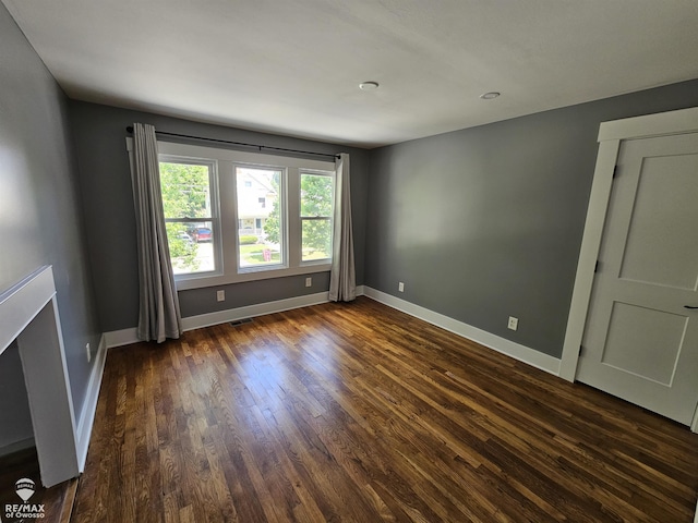 624 E Comstock St, Owosso, MI 48867 - empty room featuring dark wood-type flooring and baseboards