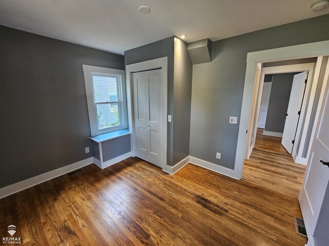 624 E Comstock St, Owosso, MI 48867 - unfurnished bedroom featuring wood finished floors and a closet