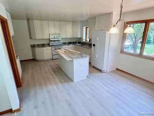 6512 White Lake Rd, Clarkston, MI 48346 - kitchen with white appliances, light wood-style floors, a center island, white cabinetry, and decorative light fixtures