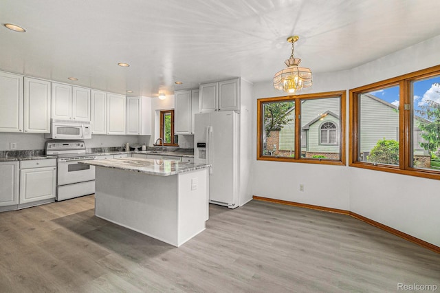 6512 White Lake Rd, Clarkston, MI 48346 - kitchen featuring white appliances, healthy amount of natural light, a chandelier, recessed lighting, and a center island