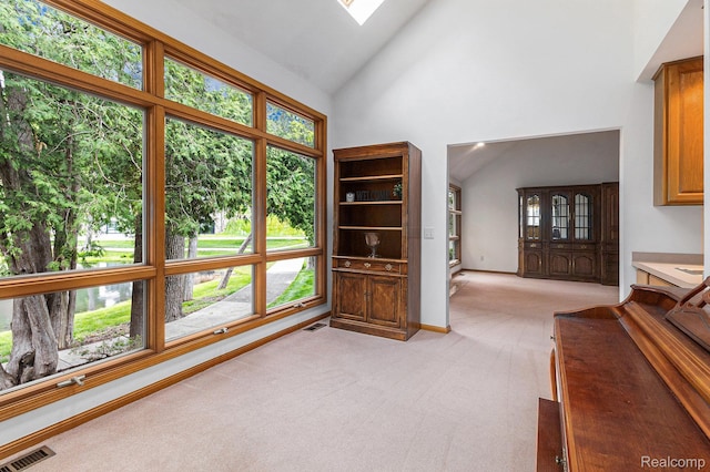 6512 White Lake Rd, Clarkston, MI 48346 - living area featuring light carpet, high vaulted ceiling, and a skylight