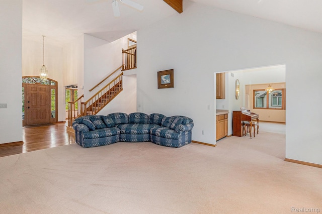 6512 White Lake Rd, Clarkston, MI 48346 - living room with light colored carpet, high vaulted ceiling, stairs, beam ceiling, and a chandelier