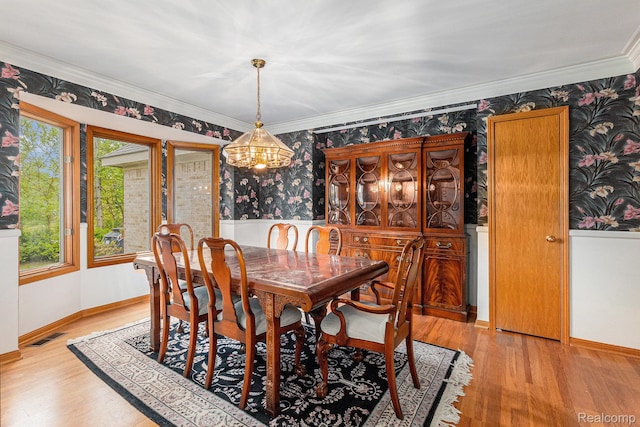 6512 White Lake Rd, Clarkston, MI 48346 - dining area with wallpapered walls, crown molding, light wood-style flooring, and a chandelier