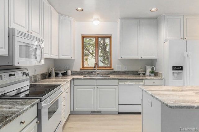6512 White Lake Rd, Clarkston, MI 48346 - kitchen with white appliances, recessed lighting, white cabinets, light wood-type flooring, and light stone counters