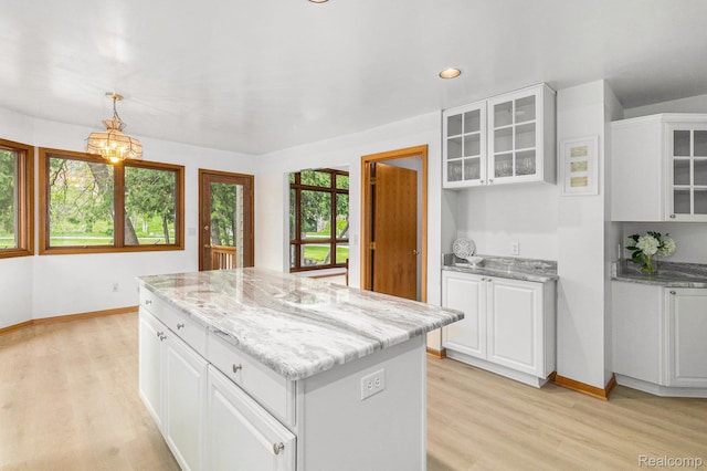 6512 White Lake Rd, Clarkston, MI 48346 - kitchen featuring light wood-type flooring, a kitchen island, white cabinetry, glass insert cabinets, and recessed lighting