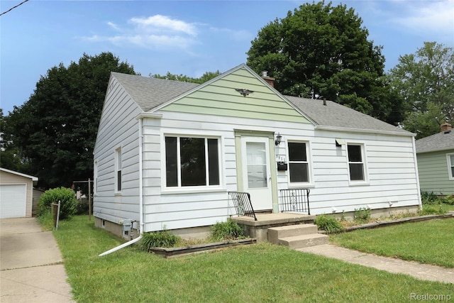 3922 Hogarth Ave, Flint, MI 48532 - bungalow-style home with an outbuilding, a front yard, and a shingled roof