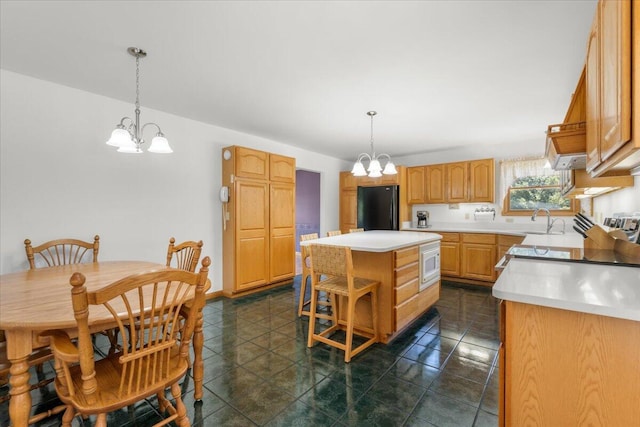 7350 N Territorial Rd, Dexter, MI 48130 - kitchen featuring freestanding refrigerator, a chandelier, a kitchen island, white microwave, and light countertops