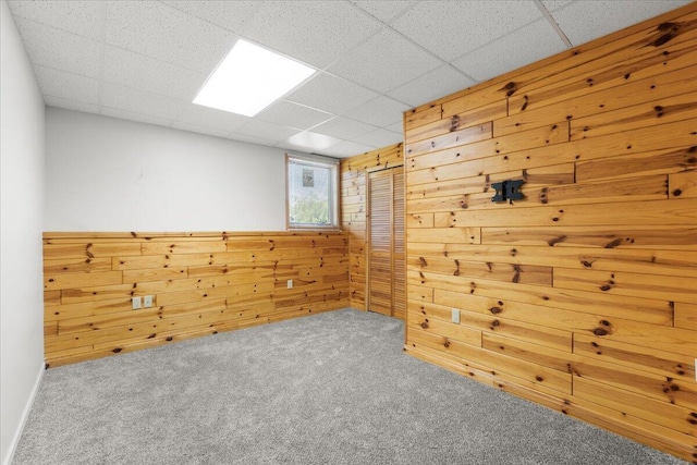 7350 N Territorial Rd, Dexter, MI 48130 - empty room with wood walls, carpet floors, and a paneled ceiling