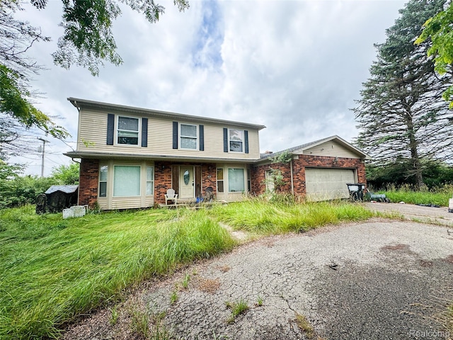 7950 Pinckney Rd, Pinckney, MI 48169 - traditional-style house with a garage, driveway, and brick siding