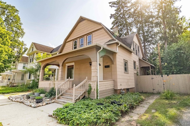 422 S Winter St, Adrian, MI 49221 - view of front facade with covered porch, a gambrel roof, roof with shingles, and a gate