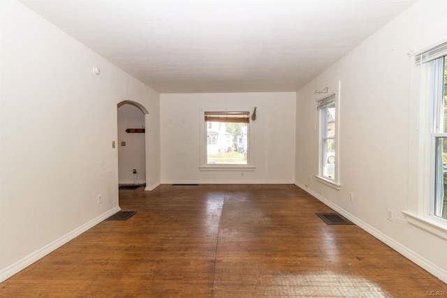 422 S Winter St, Adrian, MI 49221 - empty room featuring arched walkways, healthy amount of natural light, and wood finished floors