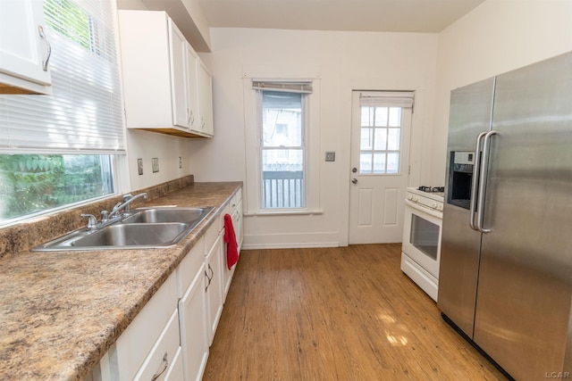 422 S Winter St, Adrian, MI 49221 - kitchen featuring stainless steel fridge, white gas range, light wood-style flooring, and white cabinetry