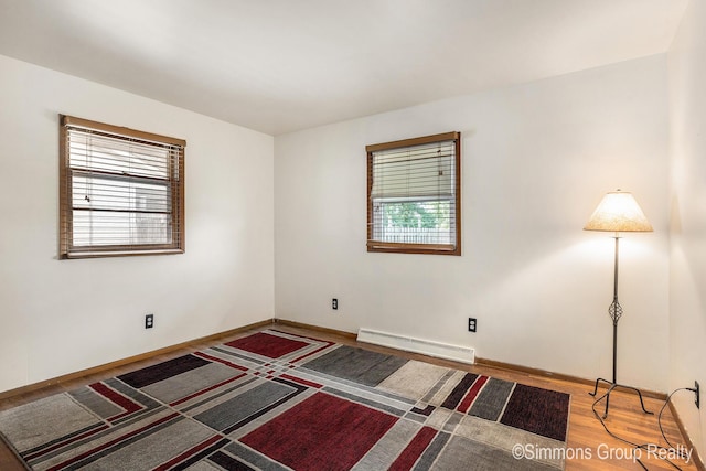 252 Jeffrey St, Cedar Springs, MI 49319 - empty room featuring a baseboard radiator, healthy amount of natural light, and wood finished floors