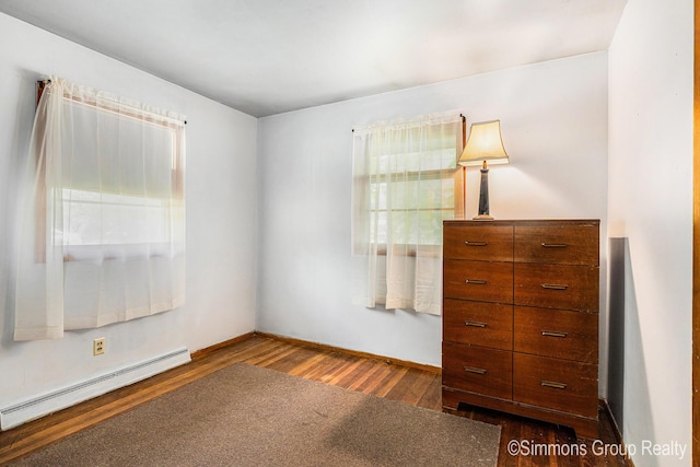 252 Jeffrey St, Cedar Springs, MI 49319 - bedroom with a baseboard heating unit and dark wood-type flooring