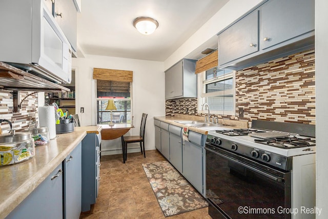 252 Jeffrey St, Cedar Springs, MI 49319 - kitchen with gas stove, gray cabinetry, backsplash, and light countertops