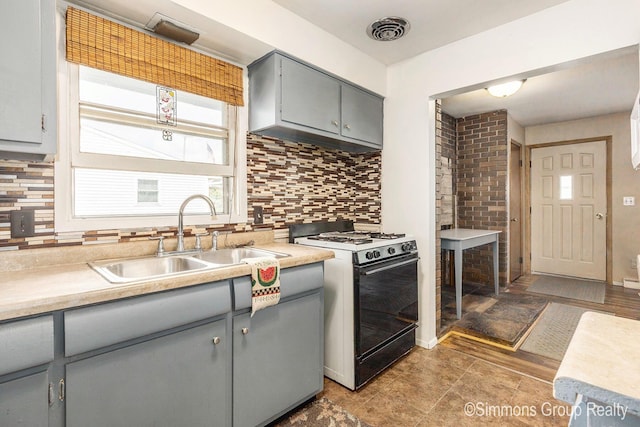 252 Jeffrey St, Cedar Springs, MI 49319 - kitchen featuring white gas range, gray cabinets, decorative backsplash, and light countertops