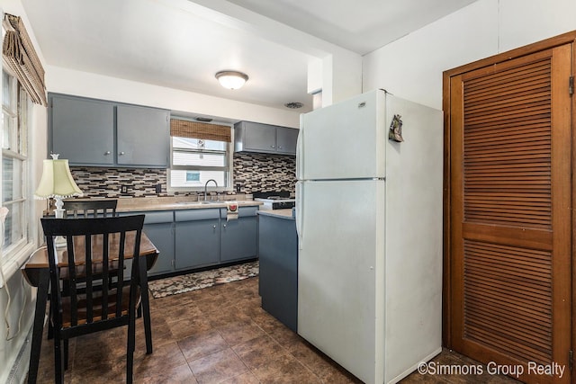 252 Jeffrey St, Cedar Springs, MI 49319 - kitchen with freestanding refrigerator, gray cabinets, backsplash, and light countertops