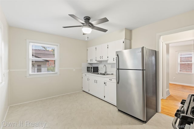 22951 Audette, Dearborn, MI 48124 - kitchen featuring stainless steel appliances, ceiling fan, plenty of natural light, and white cabinets