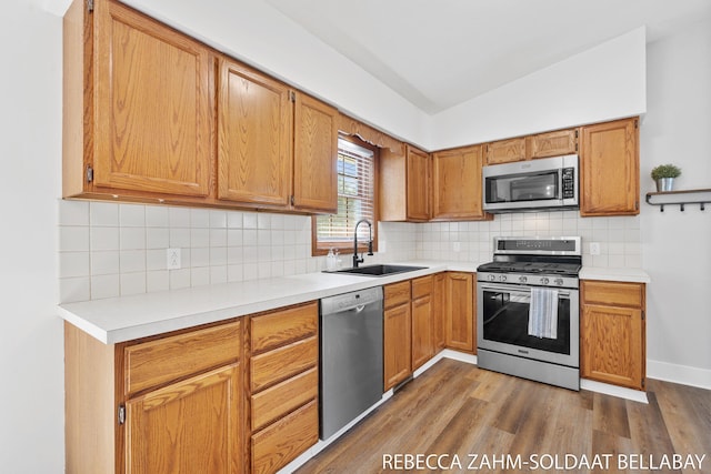 3520 Auburn Ave NE, Grand Rapids, MI 49525 - kitchen featuring appliances with stainless steel finishes, dark wood-type flooring, vaulted ceiling, and light countertops