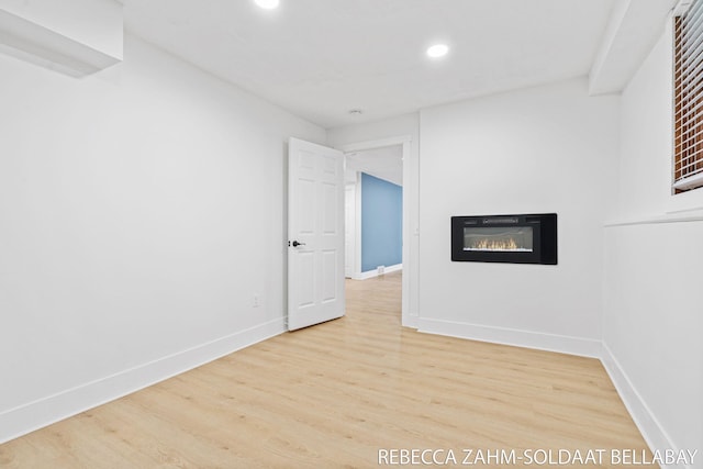 3520 Auburn Ave NE, Grand Rapids, MI 49525 - unfurnished room featuring recessed lighting, a glass covered fireplace, and wood finished floors