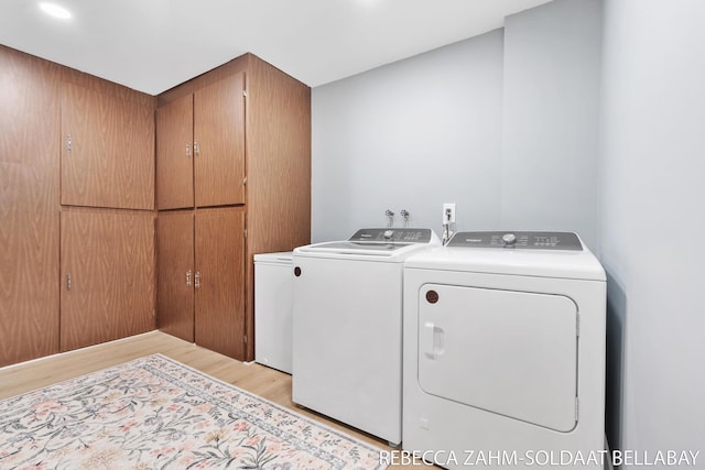 3520 Auburn Ave NE, Grand Rapids, MI 49525 - washroom with washing machine and dryer, light wood finished floors, and cabinet space
