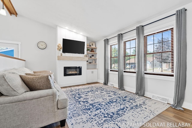 3520 Auburn Ave NE, Grand Rapids, MI 49525 - living room with wood finished floors, lofted ceiling, a glass covered fireplace, and recessed lighting