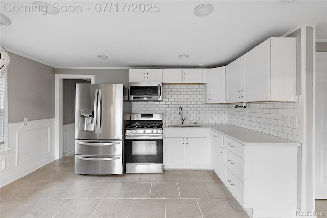 5869 Marvin St, Taylor, MI 48180 - kitchen with stainless steel appliances, light countertops, decorative backsplash, white cabinetry, and wainscoting
