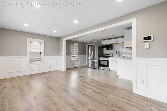 5869 Marvin St, Taylor, MI 48180 - unfurnished living room with wainscoting, a decorative wall, recessed lighting, and light wood-style flooring