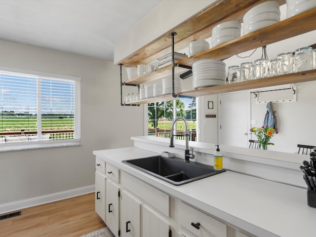 1140 Wing Dr, Ann Arbor, MI 48103 - kitchen featuring open shelves, light wood finished floors, healthy amount of natural light, and white cabinetry