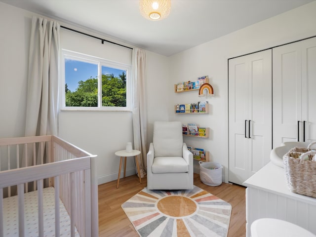 1140 Wing Dr, Ann Arbor, MI 48103 - bedroom featuring light wood-type flooring, a crib, and a closet