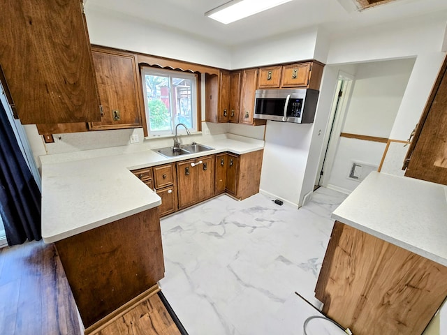 27751 Palomino Ave, Warren, MI 48093 - kitchen with stainless steel microwave, brown cabinets, light marble finish flooring, and light countertops