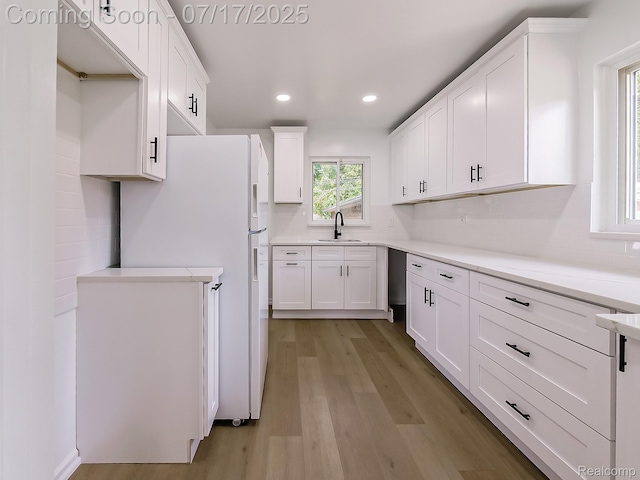2314 Middlebelt Rd, West Bloomfield, MI 48324 - kitchen featuring light wood finished floors, white cabinets, freestanding refrigerator, recessed lighting, and light countertops