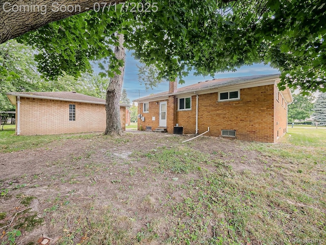 2314 Middlebelt Rd, West Bloomfield, MI 48324 - rear view of property featuring brick siding, entry steps, and a chimney