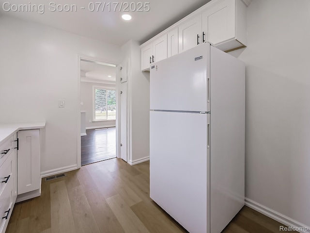 2314 Middlebelt Rd, West Bloomfield, MI 48324 - kitchen with freestanding refrigerator, wood finished floors, white cabinetry, recessed lighting, and light countertops