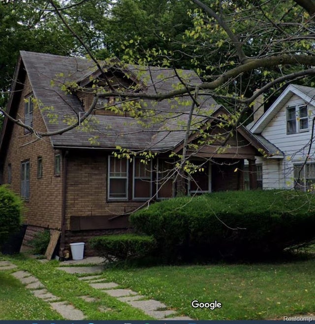 12095 Cheyenne St, Detroit, MI 48227 - view of front facade with brick siding, a front lawn, and a shingled roof