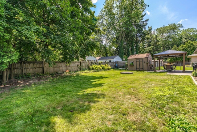 923 Par 4 Rd, Kalamazoo, MI 49008 - fenced backyard with a gazebo, a storage unit, an outdoor fire pit, and a patio area