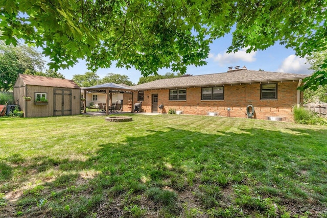 923 Par 4 Rd, Kalamazoo, MI 49008 - back of house featuring a gazebo, a shed, brick siding, a patio area, and an outdoor fire pit