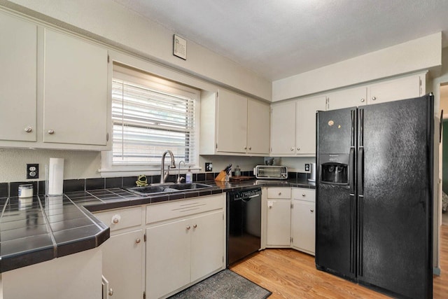 923 Par 4 Rd, Kalamazoo, MI 49008 - kitchen with black appliances, light wood-style flooring, and tile counters