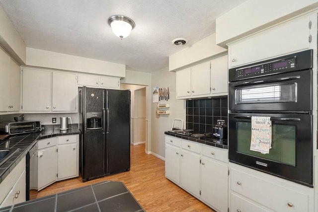923 Par 4 Rd, Kalamazoo, MI 49008 - kitchen featuring black appliances, white cabinets, light wood-type flooring, and tile countertops