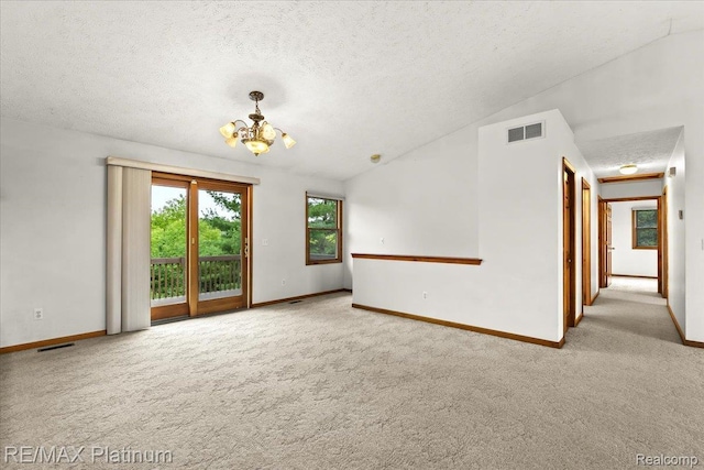 6893 Sanford Rd, Howell, MI 48855 - carpeted spare room featuring a chandelier, a textured ceiling, and lofted ceiling