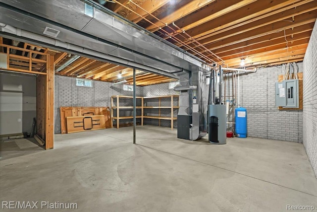 6893 Sanford Rd, Howell, MI 48855 - basement featuring electric panel, heating unit, water heater, a water pressure tank, and brick wall